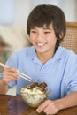 Young boy in dining room eating chinese food Royalty Free Stock Photo