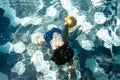 A young boy diving and taking out of the swimming pool a sea sponge. Creative concept for hotel resort or travel agency Royalty Free Stock Photo