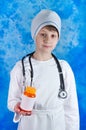 Young boy in doctor's costume holding pills bottle