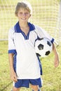 Young Boy Dressed In Soccer Kit Standing By Goal Royalty Free Stock Photo