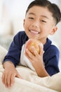 Young boy eating apple in living room Royalty Free Stock Photo