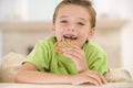 Young boy eating cookie in living room smiling Royalty Free Stock Photo