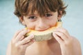 Young Boy Eating Slice Of Melon Royalty Free Stock Photo