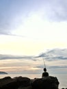 boy fishing at athe rocky beach