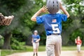 Young boy enjoying a game of baseball wearing Rawlings helmets and a blue shirt with the US flag