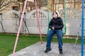 Young boy enjoying a quiet afternoon on a swing set in a backyard during early spring Royalty Free Stock Photo