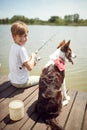 Young Boy Enjoys Fishing With His Dog