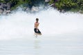 Young boy enjoys the summer holiday at beach, escaping from big splashing wave.