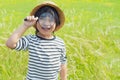 Young boy exploring nature in the meadow with a magnifying glass looking at flowers. Curious children in the woods