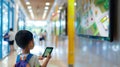 Young Boy Exploring with a Tablet in a School Hallway Royalty Free Stock Photo