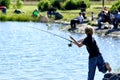 A young boy fishes at a fishing pond. Royalty Free Stock Photo