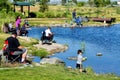 A young boy fishes at a fishing pond.