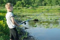 Young boy fishing at river coast.