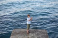 A young boy with a fishing rod fishing in the sea Royalty Free Stock Photo