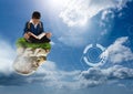 Young boy on floating rock platform in sky reading book with futuristic interface Royalty Free Stock Photo