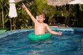 young boy in a floting tire enjoys fresh pool water Royalty Free Stock Photo