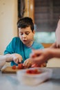 Young boy learning to cook slicing vegetables in kitchen Royalty Free Stock Photo