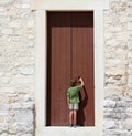 Young boy in front of a big door Royalty Free Stock Photo