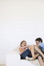 Young boy and girl laughing on couch in weatherboard room Royalty Free Stock Photo