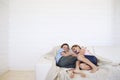 Young boy and girl laughing on couch in weatherboard room Royalty Free Stock Photo