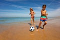 Young boy and girl play soccer ball on the beach Royalty Free Stock Photo