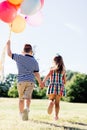 Young boy and a girl running with a bunch of colorful balloons. Royalty Free Stock Photo