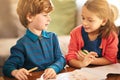 Young boy, girl and talking with colour pencil and book for drawing, indoor activities and learning development on