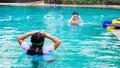 Young boy and girl wearing goggles swimming in pool having fun together Royalty Free Stock Photo