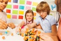 Young boy and girls assembling molecule model Royalty Free Stock Photo