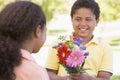 Young boy giving young girl flowers Royalty Free Stock Photo