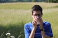 Young boy with glasses blowing his nose because of allergy in th Royalty Free Stock Photo