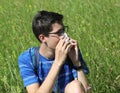 Young boy with glasses blowing his nose because of allergy in th Royalty Free Stock Photo