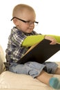 Young boy with glasses reading Royalty Free Stock Photo