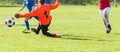 Young Boy Goalkeeper Saving A Football In A Game Of Soccer