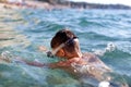 Young boy in goggles looking down in sea