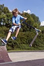 Young boy going airborne with his scooter Royalty Free Stock Photo