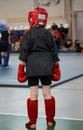 Young boy sportsmen fighter in a gloves and a protective headgear before going into the ring