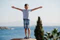 Young boy hands up at Turkey resort against Mediterranean Sea