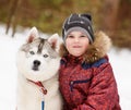 Young boy and hasky dog together in winter park