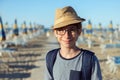 Young boy in hat and glasses posing at the summer beach. Cute smiling happy 12 years old boy at seaside, looking at camera Royalty Free Stock Photo