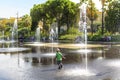 A young boy with a hat plays and splashes in the Promenade du Paillon Park in the touristic old town area of Nice, France.