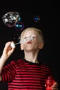 Young boy having fun blowing soap bubbles