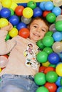 Young boy having fun in colored balls Royalty Free Stock Photo