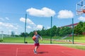 Young boy having fun playing basketball outdoors.nice,cool caucasian alone player playing basketball outdoors