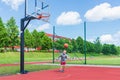 Young boy having fun playing basketball outdoors.nice,cool caucasian alone player playing basketball outdoors