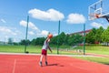 Young boy having fun playing basketball outdoors.nice,cool caucasian alone player playing basketball outdoors