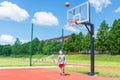 Young boy having fun playing basketball outdoors.nice,cool caucasian alone player playing basketball outdoors