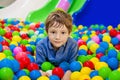 Young boy having fun playing with colorful plastic balls. Royalty Free Stock Photo