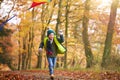 Young Boy Having Fun Running Along Path Through Autumn Woodland Flying Kite Royalty Free Stock Photo