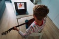 Young boy having guitar lesson online at home